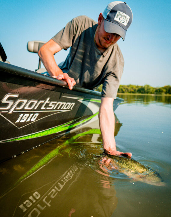 Here’s an angler releasing a summer bass.  Crankbaits fished on weedlines for bass is a great summer fishing pattern!
