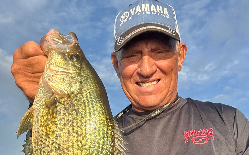 Mike Frisch with a big fall crappie caught in green weeds.